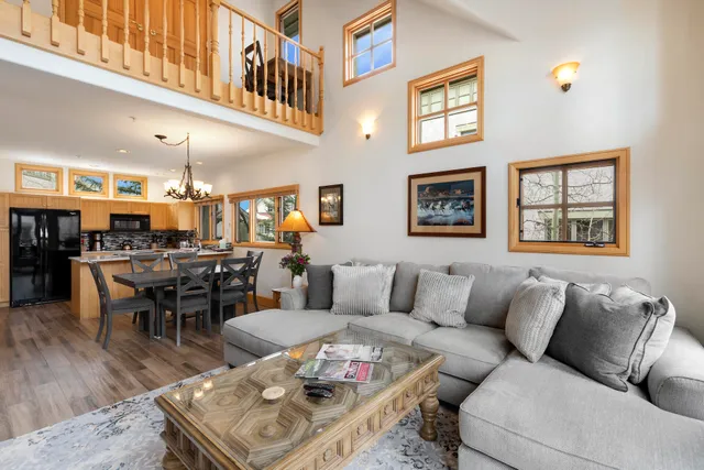 a view of a dining room with furniture a chandelier and wooden floor