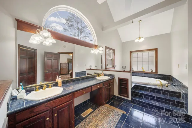 a spacious bathroom with a double vanity sink large mirror and a bathtub