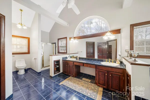 a large bathroom with a sink a toilet and a mirror