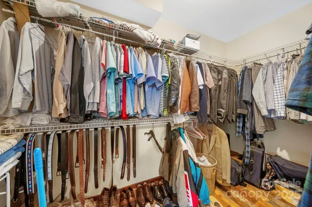 a view of walk in closet with clothes