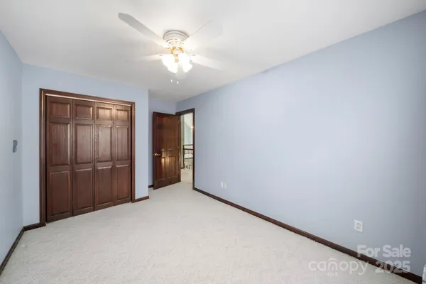 a view of an empty room with a chandelier fan