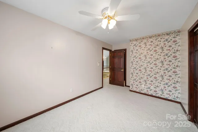 an empty room with a ceiling fan and a window