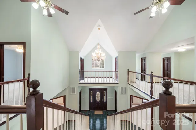 a view of a hallway with couches and chandelier