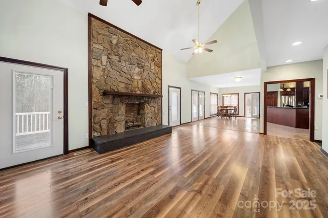 a view of an empty room with window and wooden floor