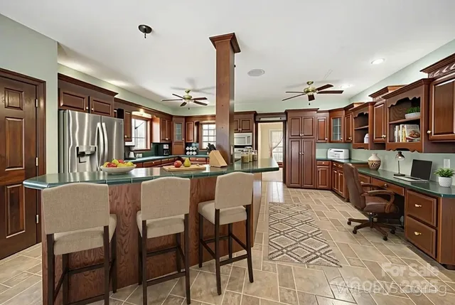 a dining hall with stainless steel appliances a dining table and chairs with wooden floor