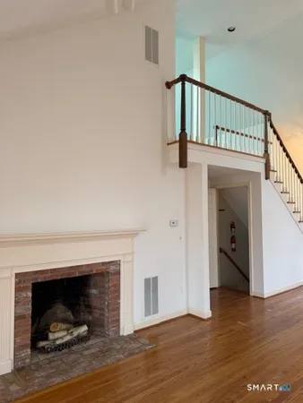 a view of a livingroom with wooden floor and a fireplace