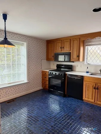 a kitchen with granite countertop a stove a sink and a microwave