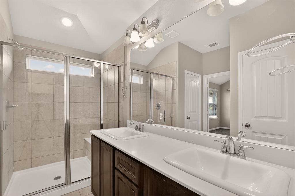 9105 Switchgrass Lane Forney, TX 75126 - Photo 11 of 20 Bathroom featuring a dual-sink vanity with white countertops and dark wood-finish cabinetry