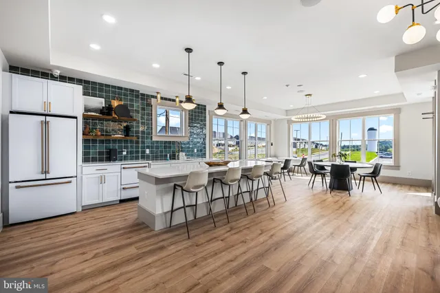 a kitchen with lots of counter and chairs