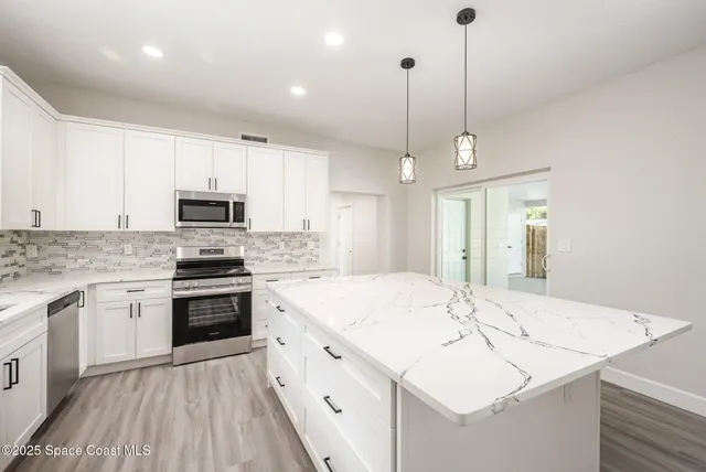 a kitchen with a sink stove and white cabinets