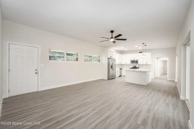 a view of a kitchen with a sink a refrigerator and window
