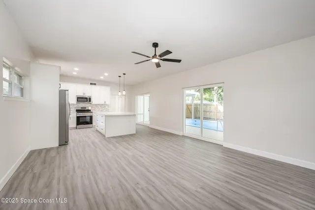 a view of a kitchen with wooden floor and a kitchen
