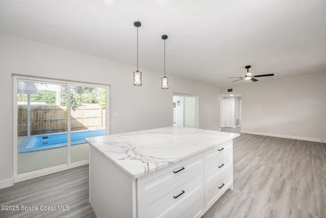 a kitchen with a stove a refrigerator a sink and wooden floor