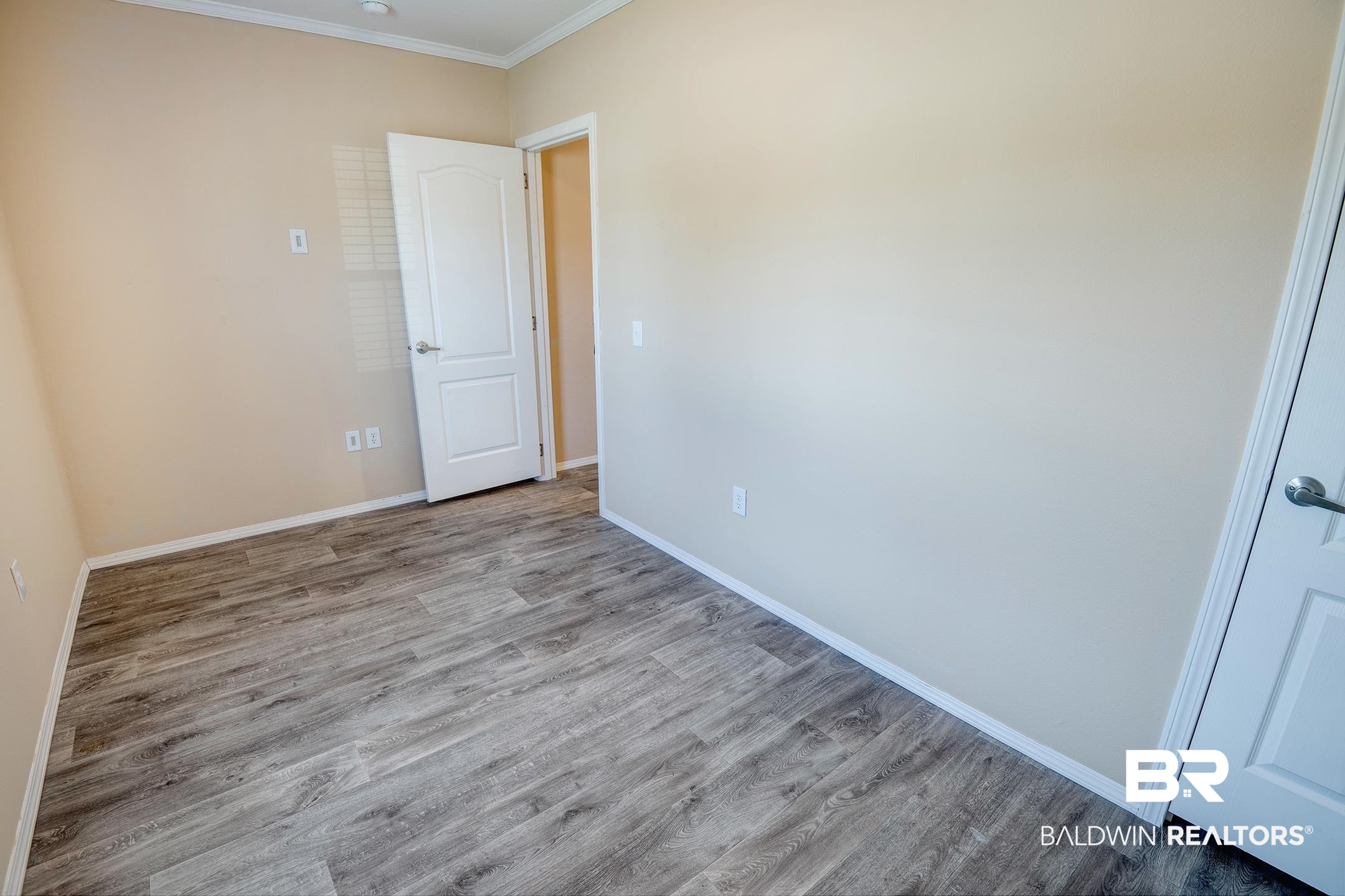 21859 West Side Loop Silverhill, AL 36576 - Photo 8 of 24 Empty room featuring ornamental molding and light hardwood / wood-style floors
