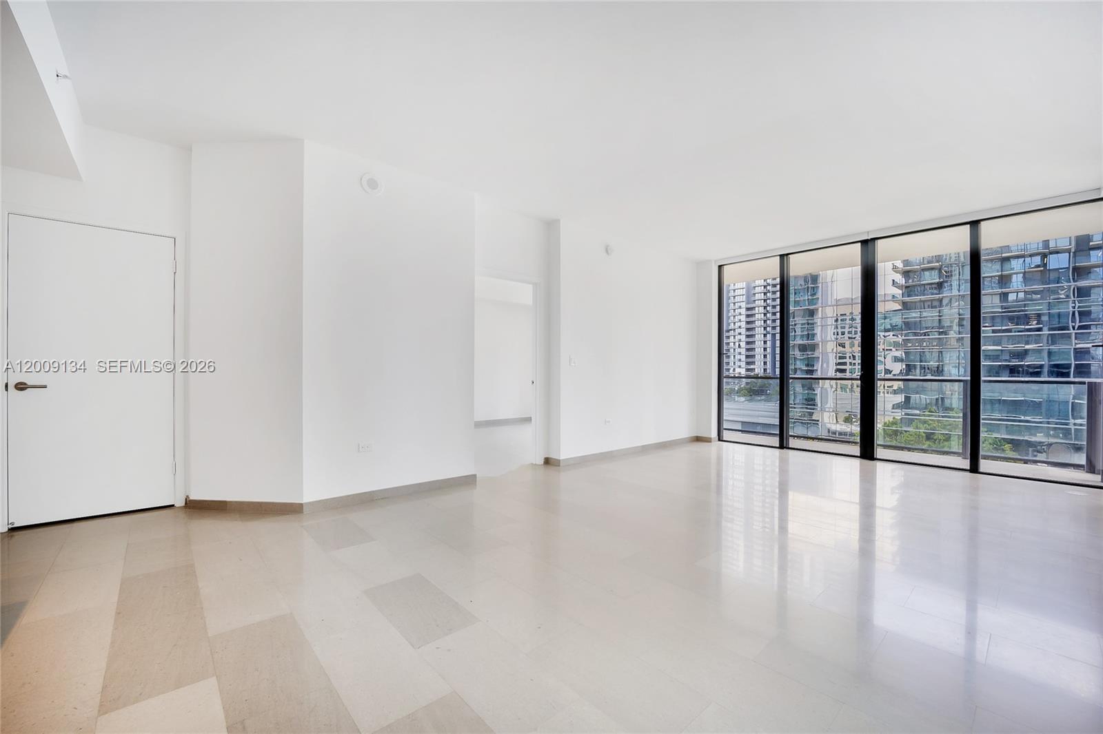 88 Southwest 7th Street, Unit 1009 Miami, FL 33130 - Photo 3 of 21 a view of an empty room with wooden floor