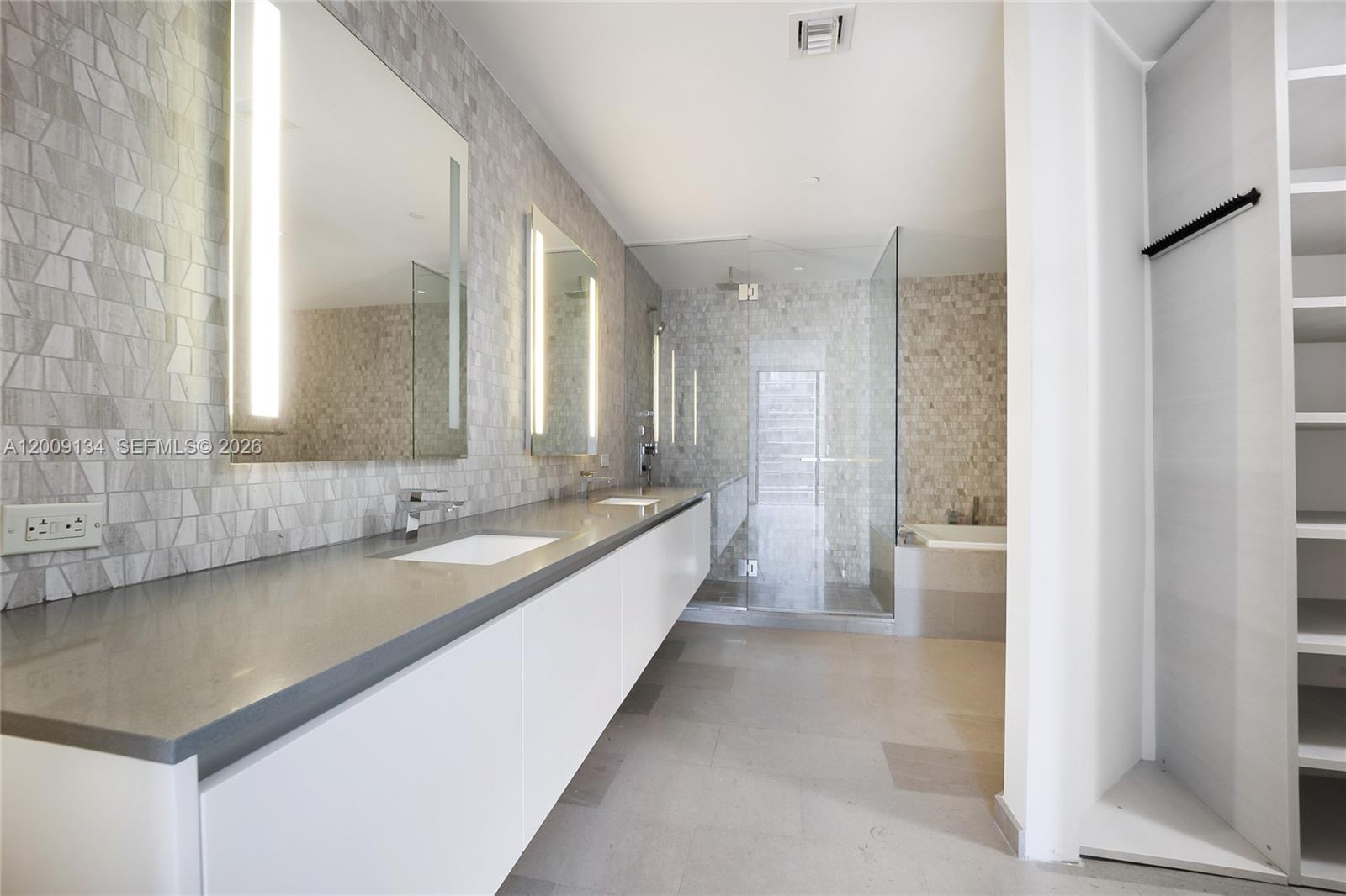 88 Southwest 7th Street, Unit 1009 Miami, FL 33130 - Photo 5 of 21 a large bathroom with a granite countertop double vanity sink a mirror and a bathtub