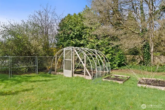 a view of a backyard with a slide trees and wooden fence