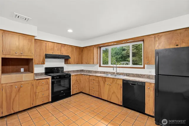 a kitchen with stainless steel appliances granite countertop a stove a sink dishwasher a refrigerator and a microwave oven