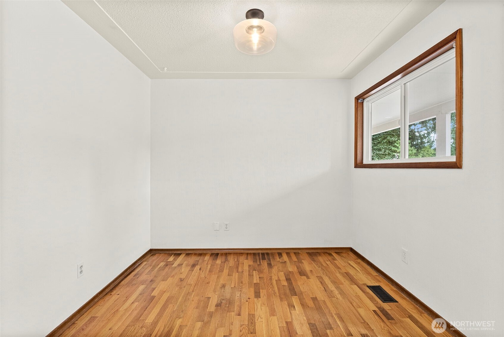 4606 15th Avenue Northeast Olympia, WA 98516 - Photo 10 of 17 a view of an empty room with wooden floor and a window