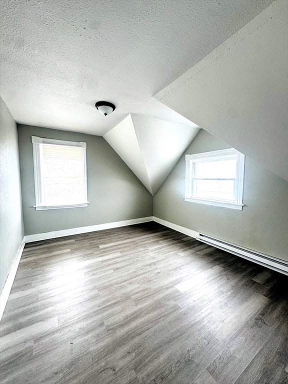 738 Central Street, Unit 2 Lowell, MA 01852 - Photo 11 of 11 an empty room with wooden floor and windows