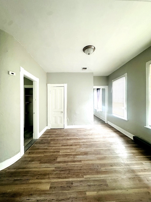 738 Central Street, Unit 2 Lowell, MA 01852 - Photo 4 of 11 a view of an empty room with window and wooden floor