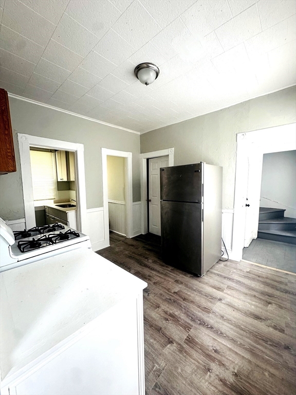 738 Central Street, Unit 2 Lowell, MA 01852 - Photo 7 of 11 a kitchen with a refrigerator and a stove top oven