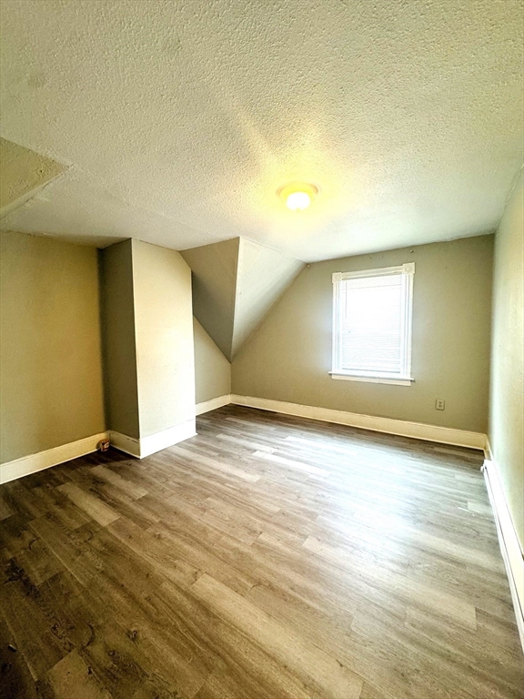 738 Central Street, Unit 2 Lowell, MA 01852 - Photo 10 of 11 an empty room with wooden floor and windows