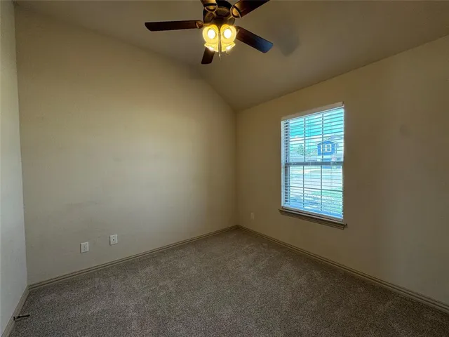 an empty room with windows and chandelier fan