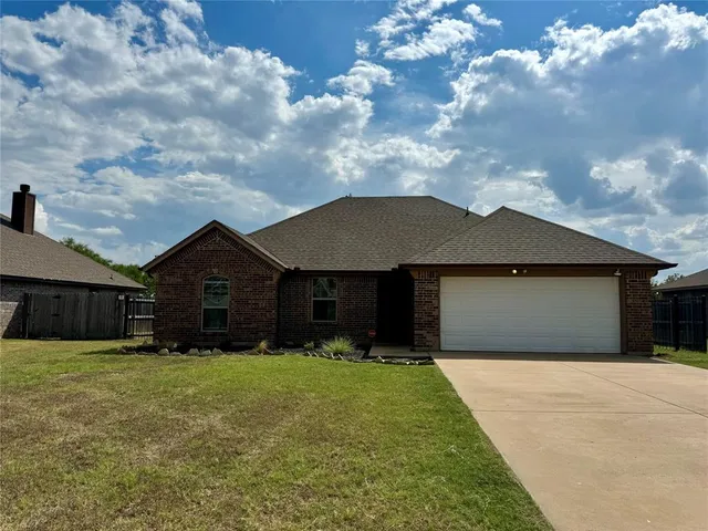 a front view of house with yard and garage