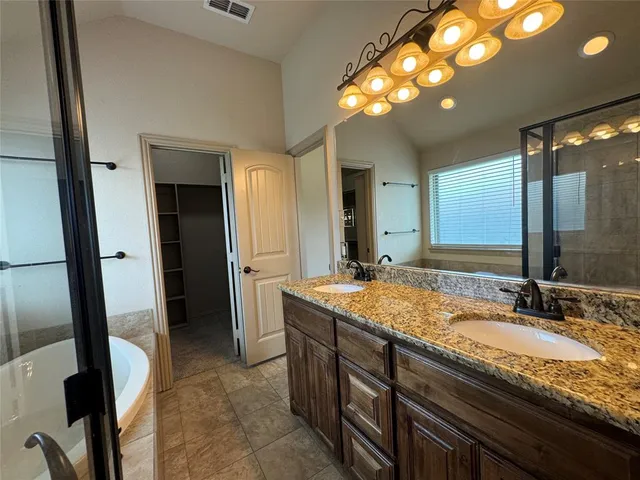 a bathroom with a granite countertop sink a large mirror and a shower