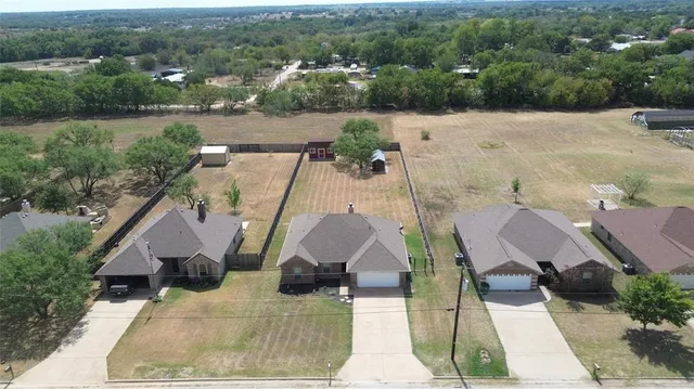 an aerial view of a house with yard and lake view