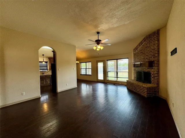 a view of a livingroom with wooden floor and a kitchen