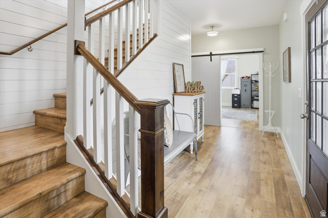 1009 High Creek Road Cove, UT 84320 - Photo 12 of 79 Staircase with a barn door and hardwood / wood-style floors
