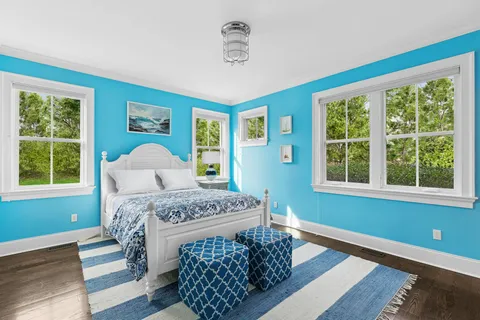 a bedroom with a bed lamp and a large window