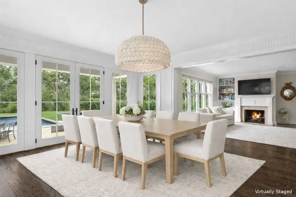 a kitchen with stainless steel appliances sink a stove a refrigerator cabinets and a dining table with wooden floor