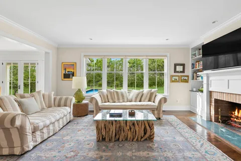 a living room with furniture a large window and a fireplace