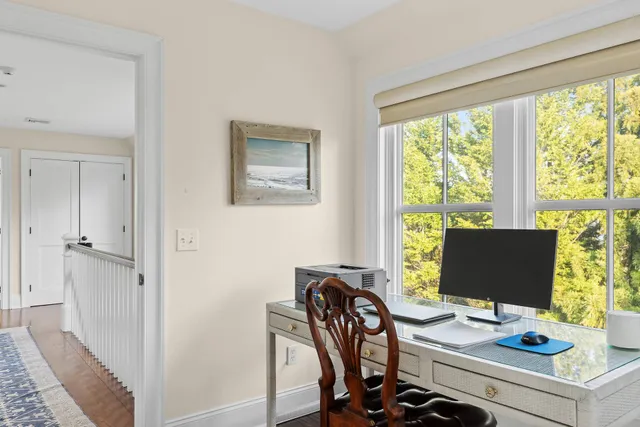 a view of a workspace with furniture and a window