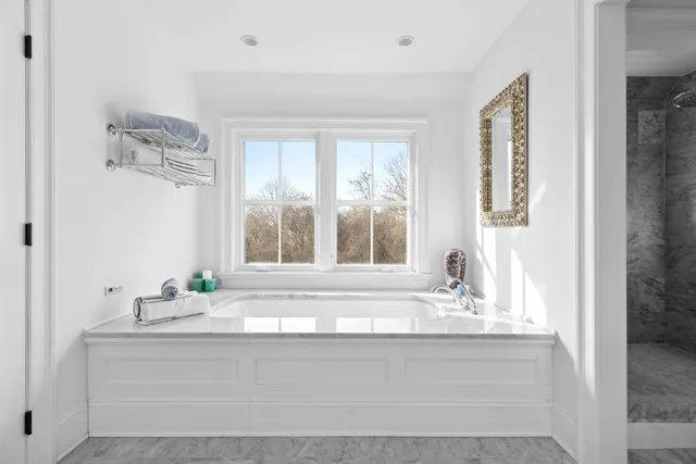 a bathroom with a granite countertop sink and a window