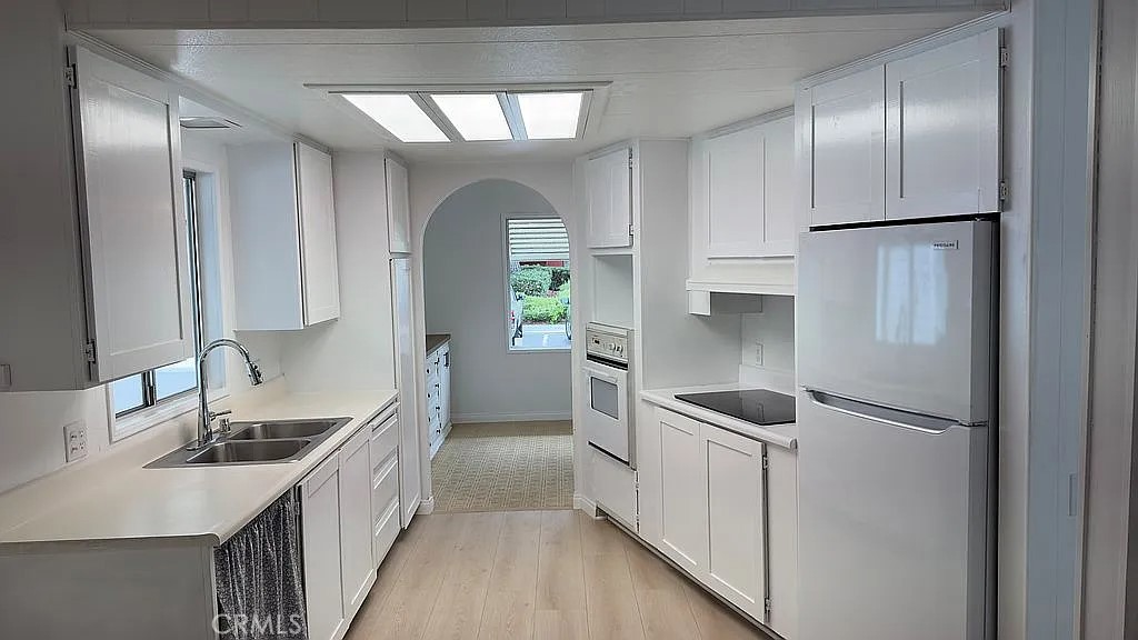 14851 Jeffrey Road, Unit 135 Irvine, CA 92618 - Photo 9 of 17 a kitchen with stainless steel appliances granite countertop a refrigerator a sink and white cabinets
