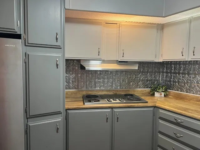 a kitchen with a refrigerator and cabinets