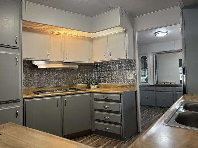 a kitchen with granite countertop a sink and cabinets