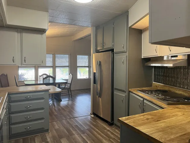 a kitchen with a refrigerator and a stove top oven