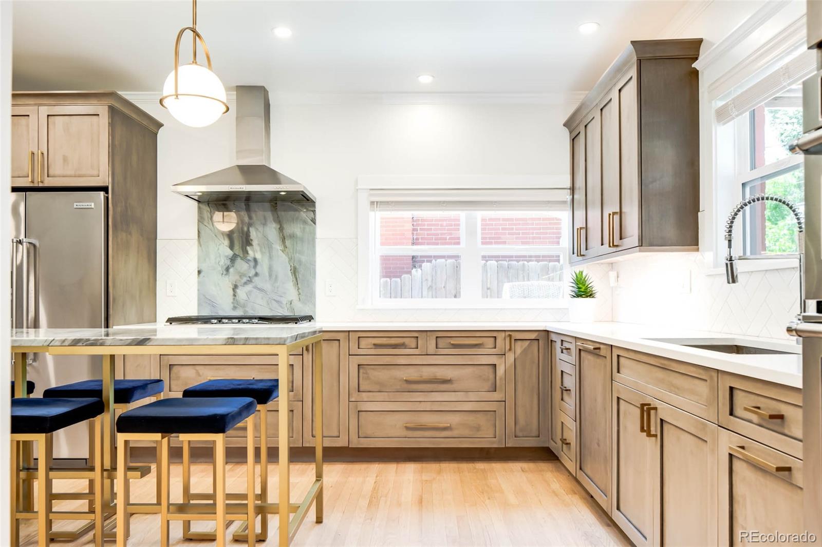 3751 Raleigh Street Denver, CO 80212 - Photo 6 of 36 a kitchen with stainless steel appliances a stove and a chandelier