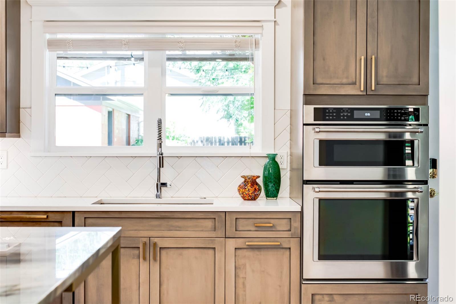 3751 Raleigh Street Denver, CO 80212 - Photo 7 of 36 a kitchen with granite countertop white cabinets and stainless steel appliances