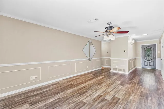 a view of a livingroom with wooden floor and a ceiling fan