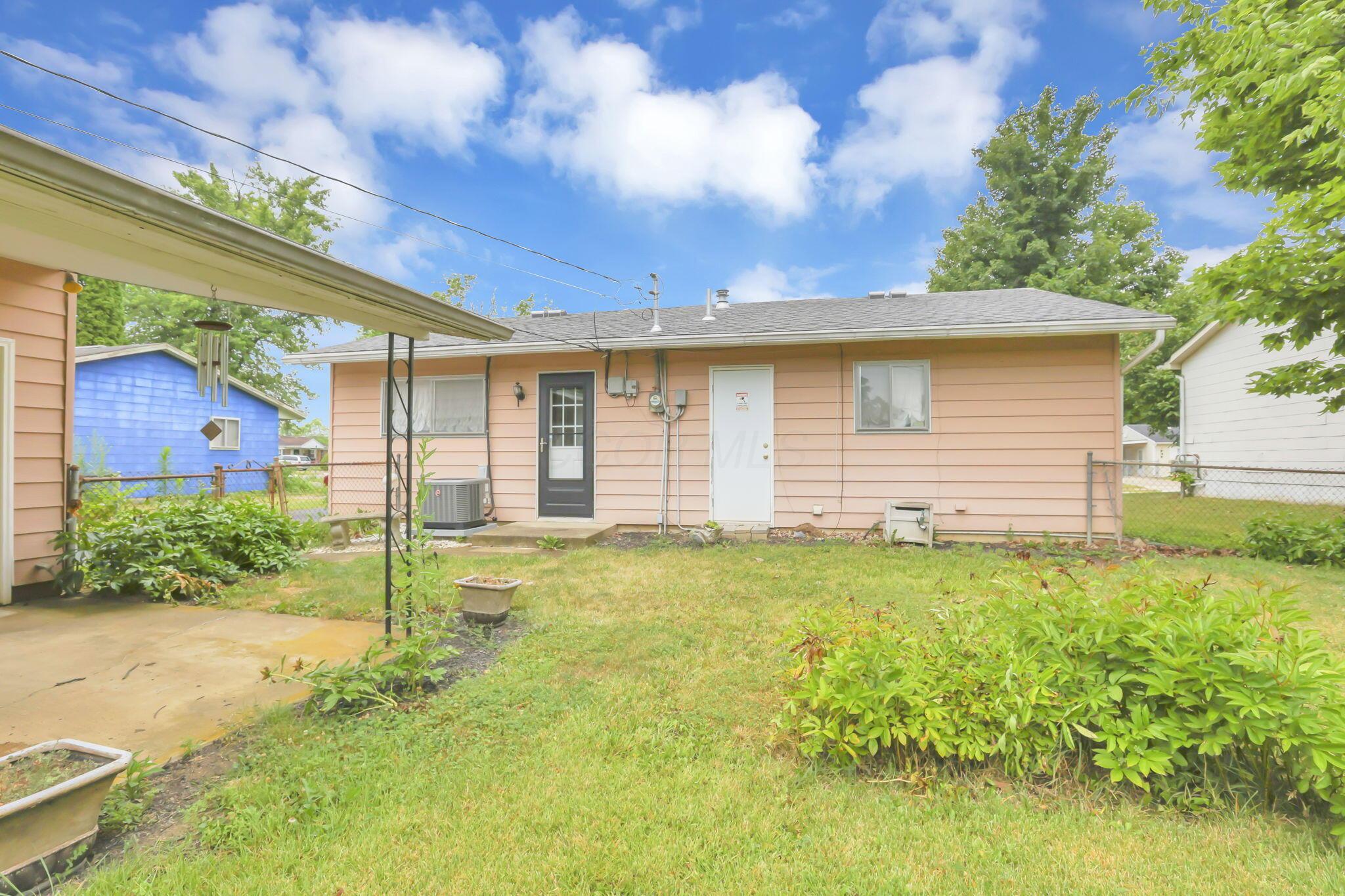 3882 Glenfield Road Columbus, OH 43232 - Photo 25 of 29 Rear exterior with light peach-colored siding and a black paneled door