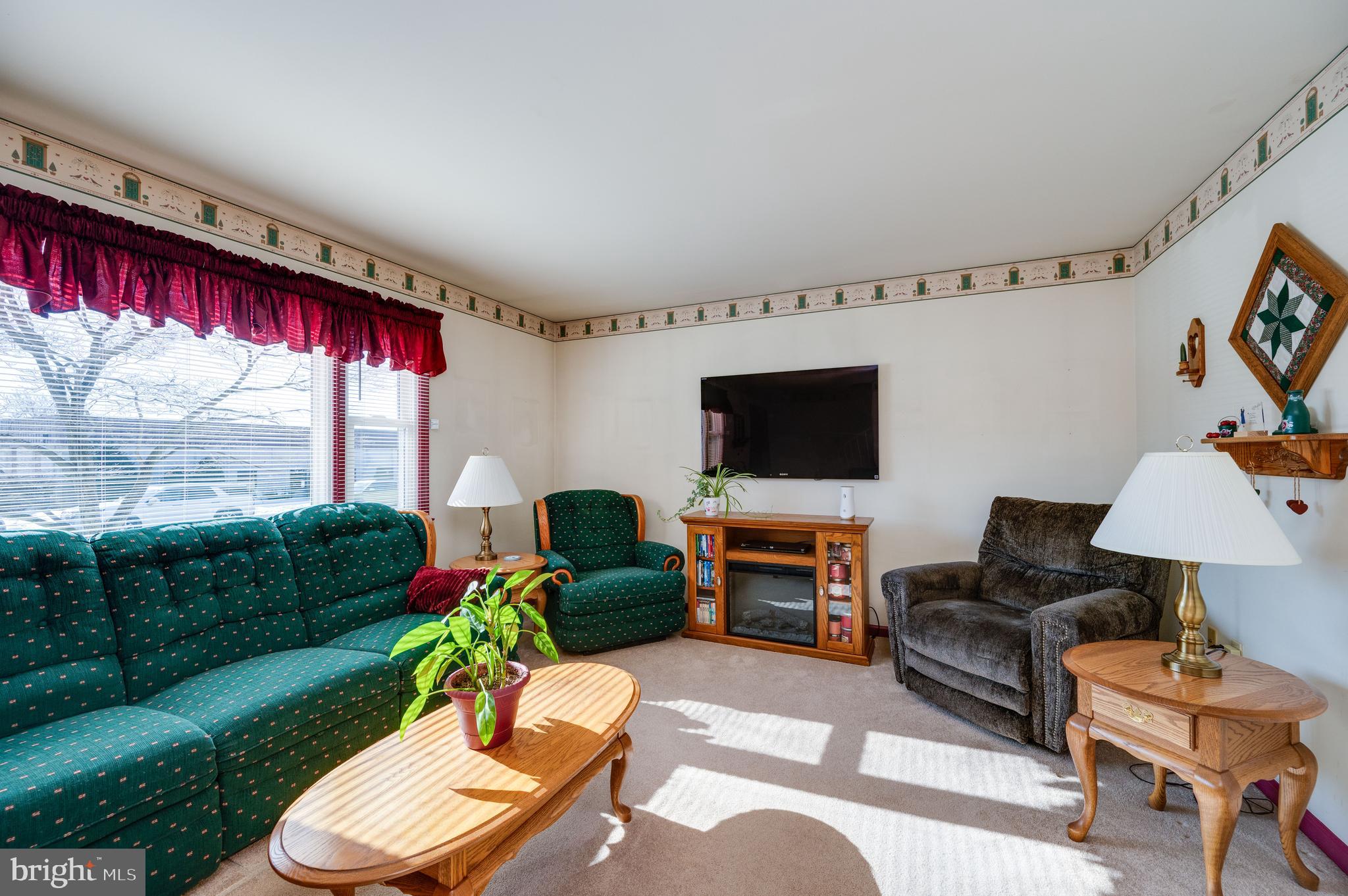 523 Mount Laurel Road Temple, PA 19560 - Photo 8 of 36 a living room with furniture a flat screen tv and a floor to ceiling window
