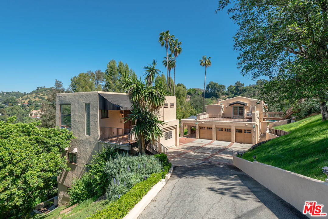 9545 Oak Pass Road Beverly Hills, CA 90210 - Photo 1 of 1 a house with green field in front of it