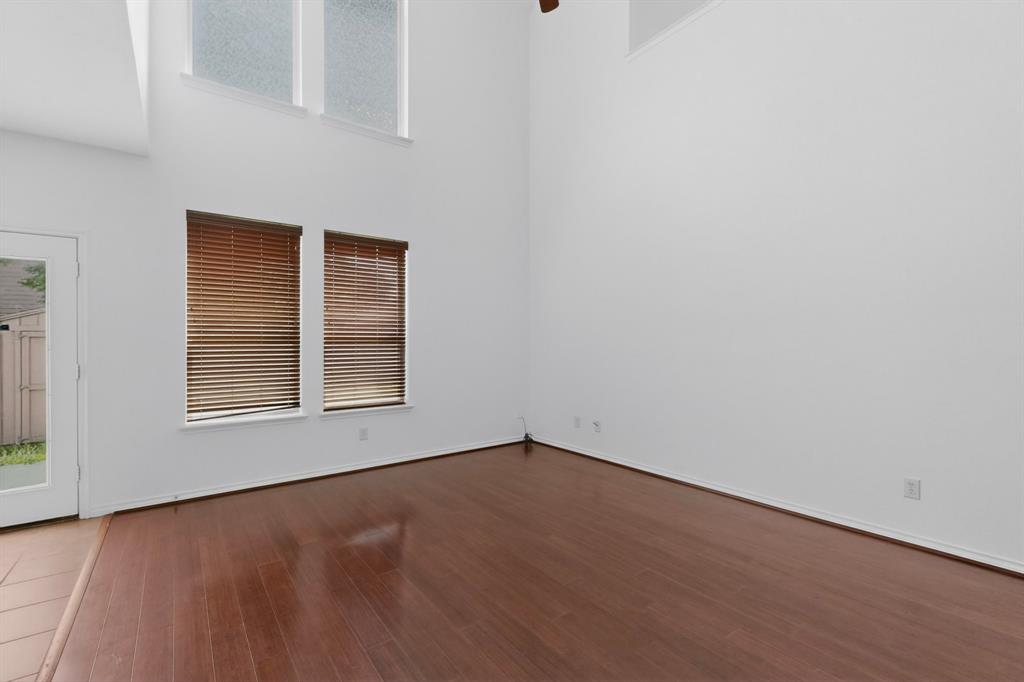 426 Harding Lane Lavon, TX 75166 - Photo 10 of 40 Spacious interior featuring wood-finish flooring, high ceilings, multiple windows with blinds, and an exterior door leading to a fenced area
