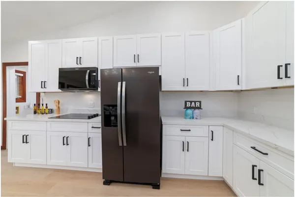 a kitchen with stainless steel appliances white cabinets and a refrigerator